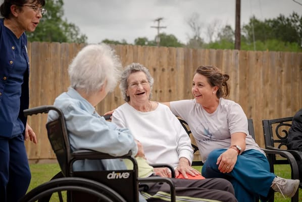 Residents enjoying outdoor conversation with staff
