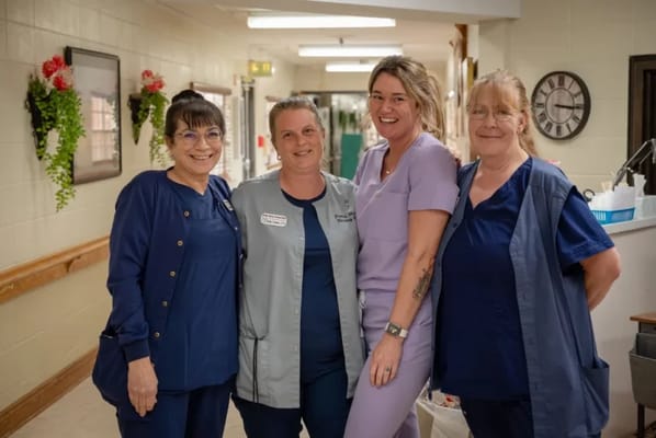 Staff members posing in a hallway.