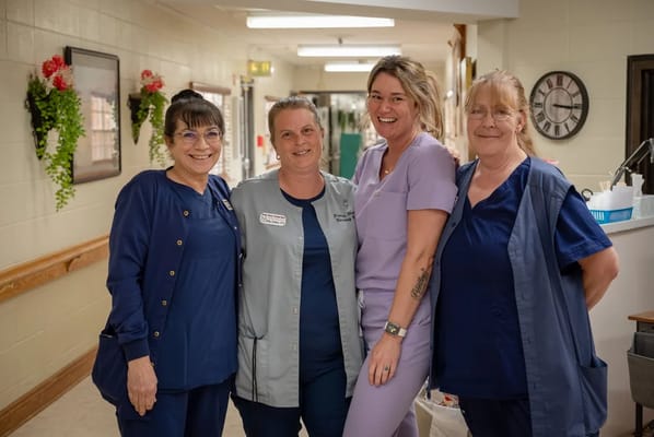 Staff members posing in a hallway.