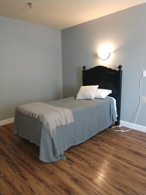 Simple bedroom setup with a bed and accent blanket