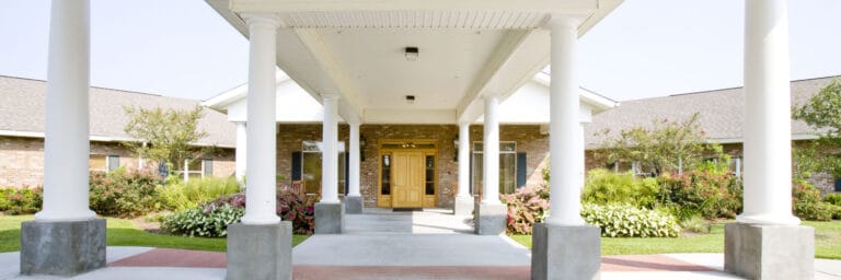 Entrance of a senior living facility with gardens