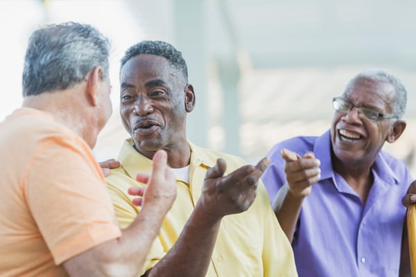 Three men enjoying a lively conversation outdoors
