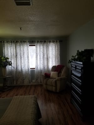 Cozy resident room with a comfortable chair and curtains