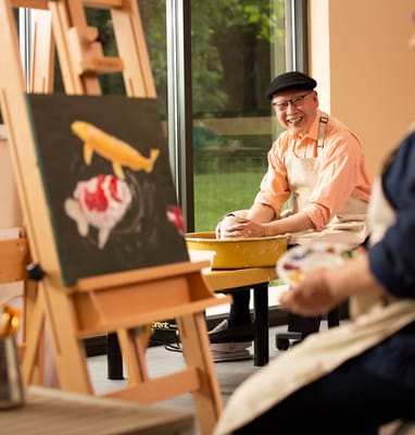 Residents engaging in an art activity in a bright room