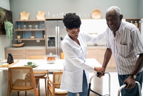 Caregiver assisting a resident in a kitchen area
