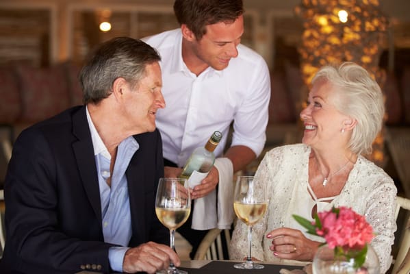 Residents enjoying white wine at a dining table