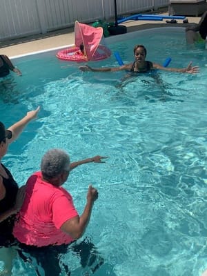 Residents enjoying a pool activity with floating devices