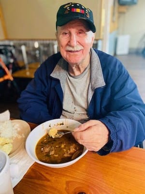 Senior man enjoying a bowl of soup at a dining table