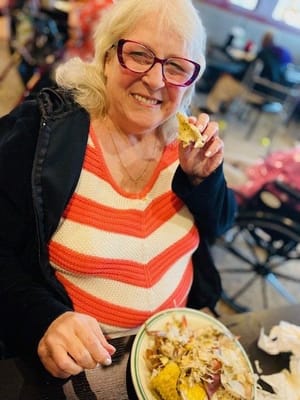 A resident enjoying a meal with a smile