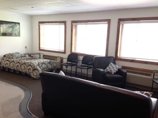 Seating area with chairs and a bed in a common room