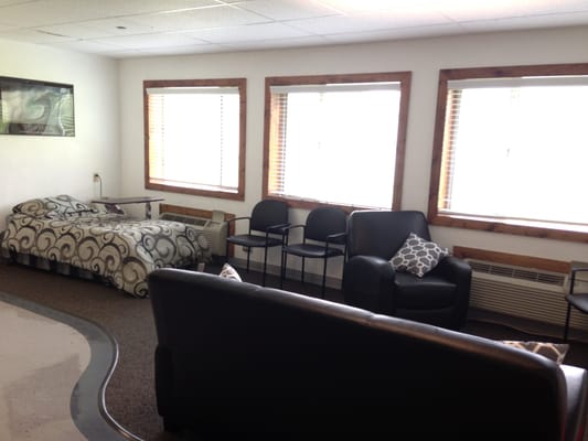 Seating area with chairs and a bed in a common room