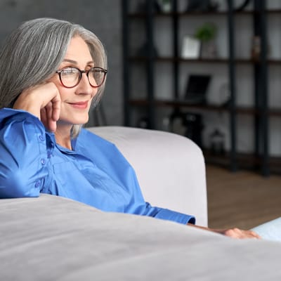 Senior woman thoughtfully relaxing in a cozy living area