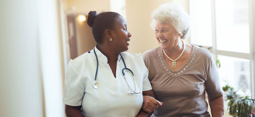 A caregiver and resident sharing a joyful moment indoors