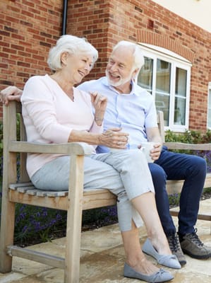 Couple enjoying conversation on a bench outdoors