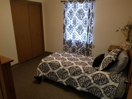 Cozy resident room with decorative bedding and curtains