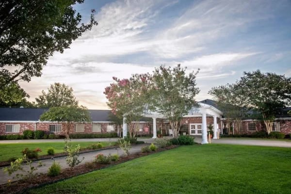 Exterior view of a senior living facility surrounded by greenery