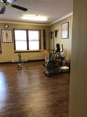 Therapy room with exercise equipment and wooden flooring
