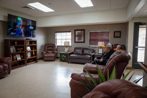Residents relaxing in a common area with a television