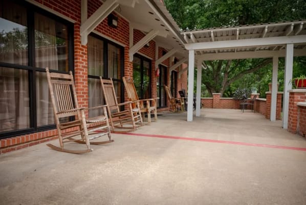 Outdoor seating area with rocking chairs and trees