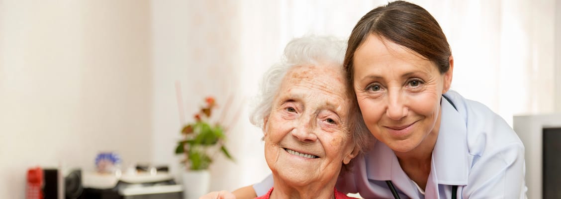 A caregiver smiling with a resident in a cozy room