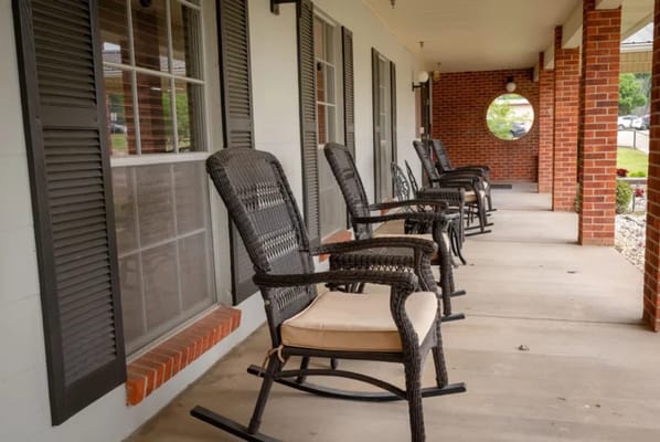 Rocking chairs on a porch outside a senior living facility