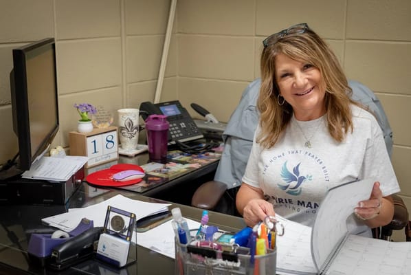 Staff member assisting at a desk in the facility