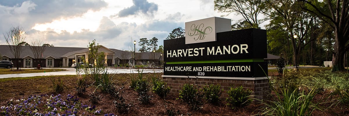 Exterior view of Harvest Manor facility signage and landscape