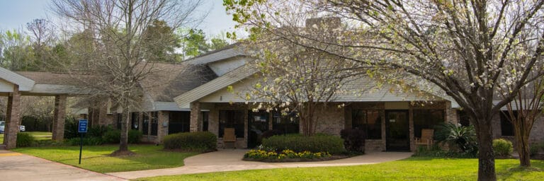 Exterior view of a senior living facility surrounded by trees