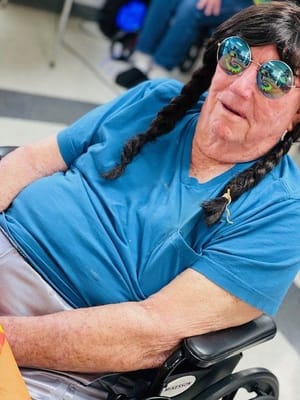 Resident in a blue shirt with sunglasses and braids