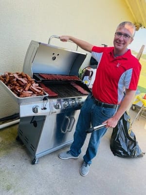 Staff member grilling food for an outdoor event