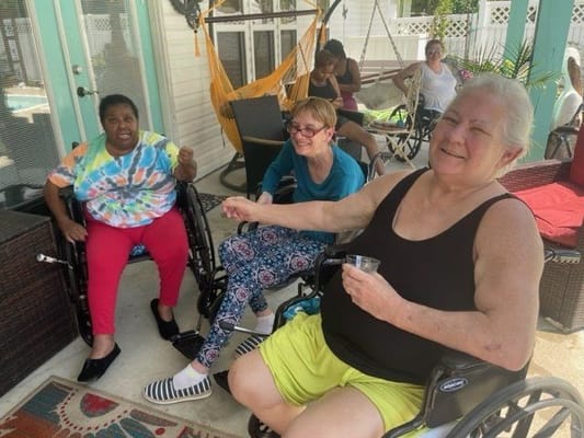 Residents enjoying a sunny day outdoors on wheelchairs