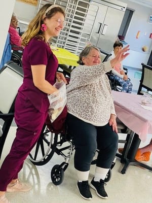 Staff member engaging with a resident during an activity