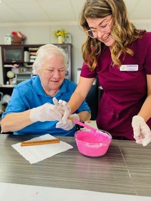 Resident and staff member engaging in a creative activity