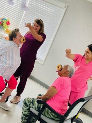 Residents and staff enjoying a fun activity with donuts