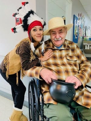 Staff member and resident dressed in costumes during an event