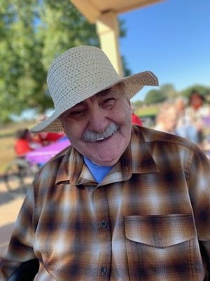 Senior man smiling outdoors in a sun hat