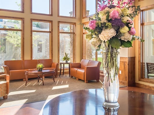 Bright common area with comfortable seating and flowers