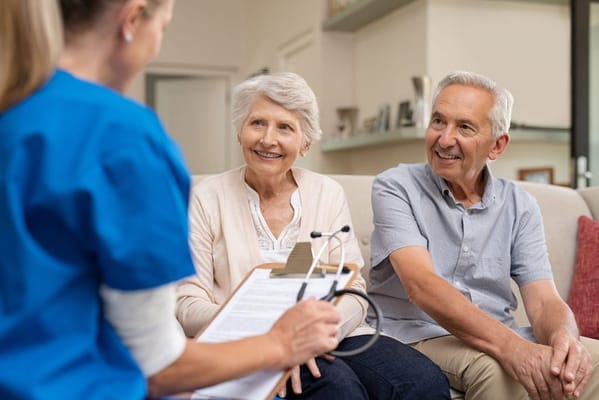 Nurse interacting with senior couple in a living room