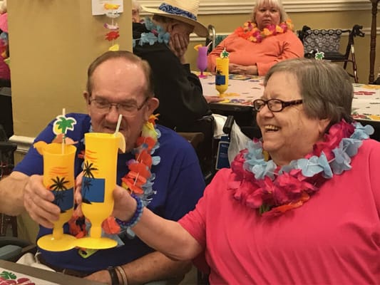Residents celebrating with drinks in a vibrant activity room