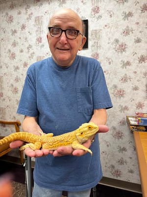Resident holding a bearded dragon in a common area