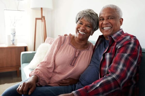 A happy senior couple smiling together on a couch