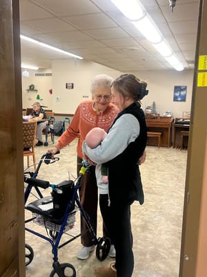 Residents interacting with a baby in a common area