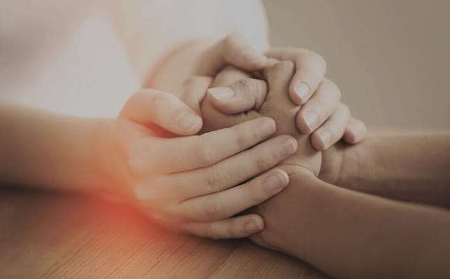 Two hands clasped together in support