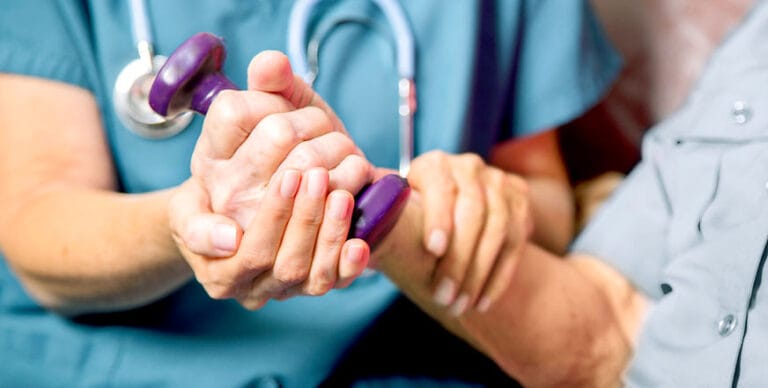 Healthcare worker assisting a resident with exercise