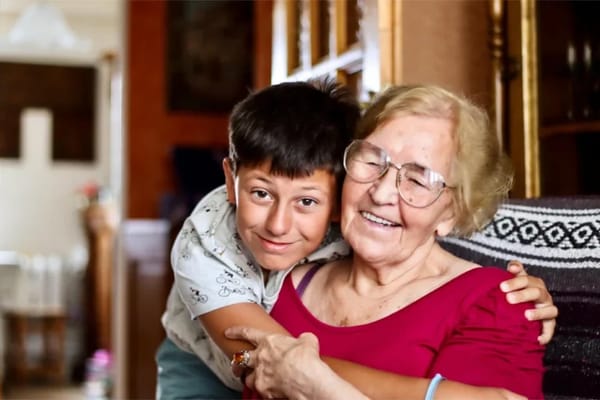 A woman and a boy smiling together in a living area