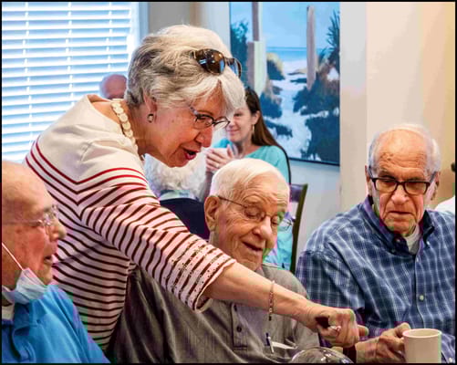 Residents enjoying a meal and conversation in a dining area
