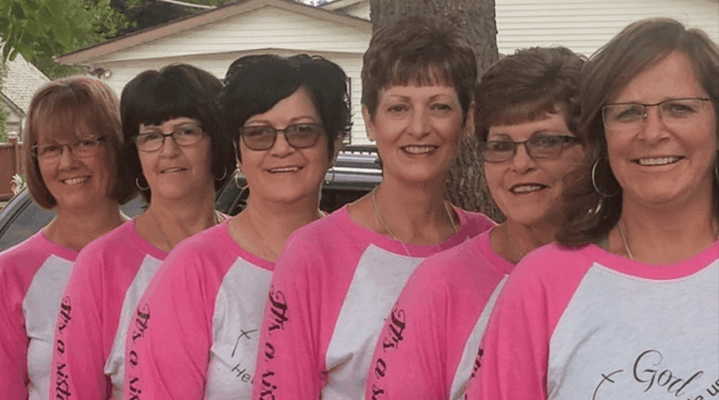 Staff members in matching shirts smiling outdoors