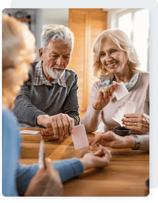 Residents enjoying a card game in a bright common area