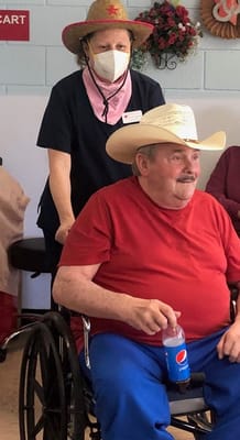 A resident being assisted in a common area by staff.