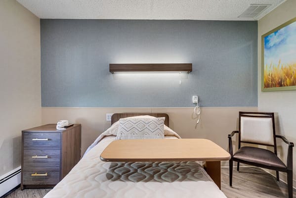 A private resident room with a bed and chair